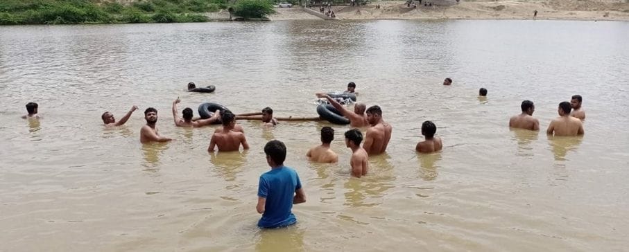 खटकड़ गांव के बरसोला रोड पर तालाब में डूबे किशोर को ढूंढते युवक। खटकड़ गांव के बरसोला रोड पर तालाब में डूबे किशोर को ढूंढते युवक।