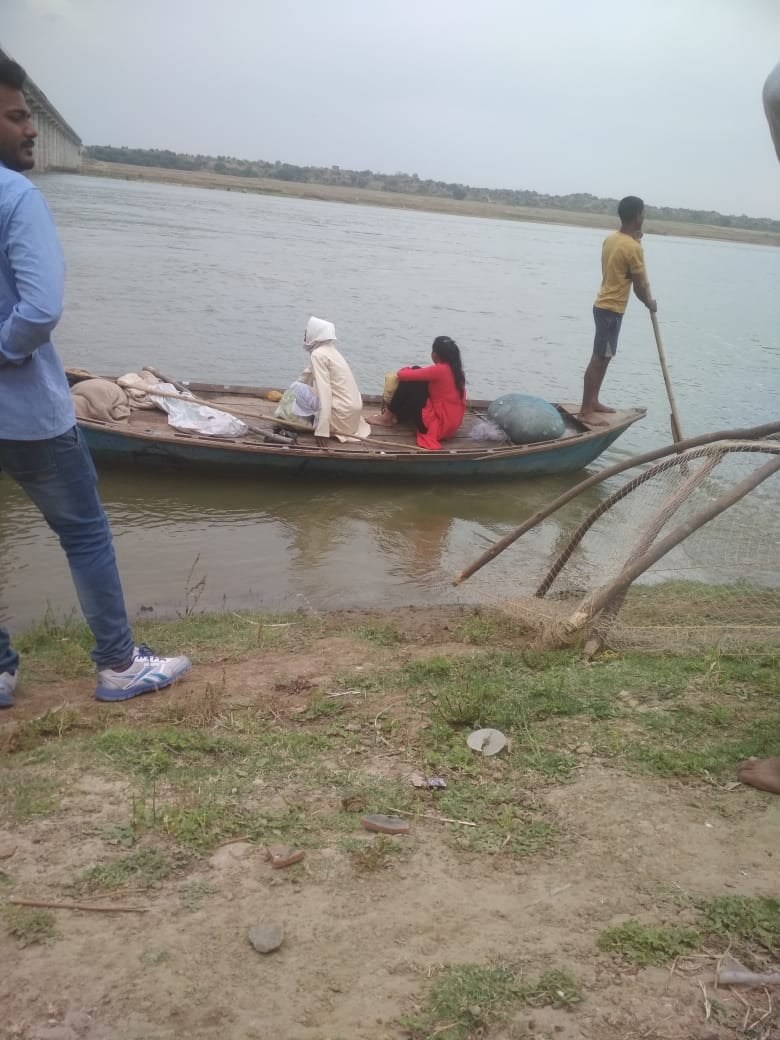 नाव से नदी पार करते लोग। नाव से नदी पार करते लोग।