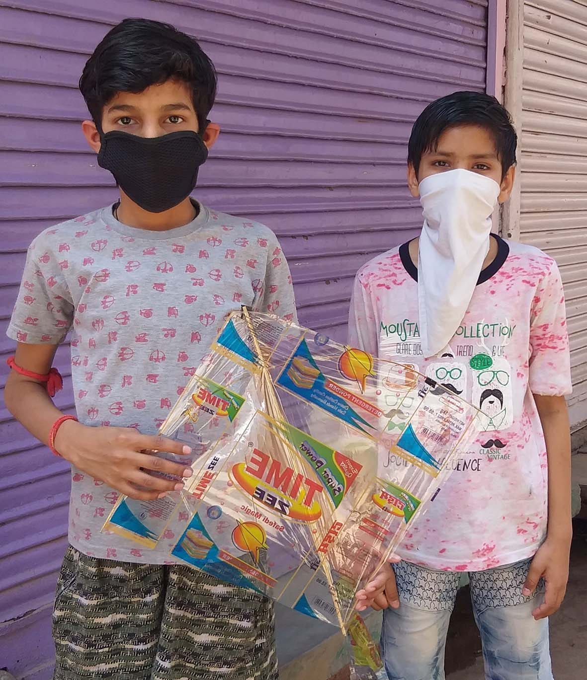 उड़ाने के लिए पतंग ले जाते बच्चे उड़ाने के लिए पतंग ले जाते बच्चे