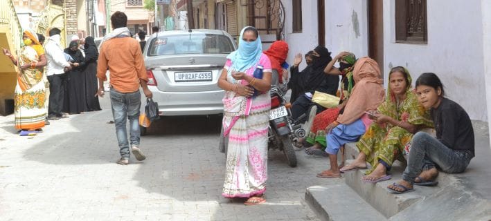 पटियाली गेट स्थित राशन की दुकान के बाहर झुंड में बैठे लोग। पटियाली गेट स्थित राशन की दुकान के बाहर झुंड में बैठे लोग।