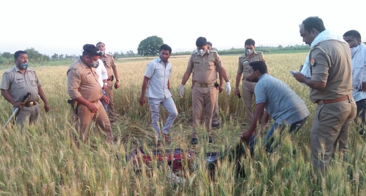 सरधना में लोकप्रिय रोड के निकट खेत में पड़े युवक के शव का पंचनामा भरती पुलिस। 