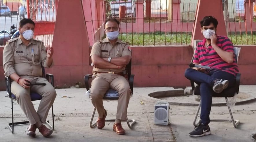 नजीबाबाद में मंडी समिति के गेट पर फुटकर कारोबारियों को रोकने बैठे थाना प्रभारी संजय शर्मा और मंड?