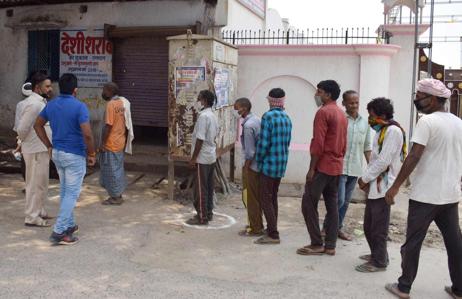 नगर के एलवल स्थित देशी शराब की दुकान पर खड़े लोग। सुबह 10.50 बजे