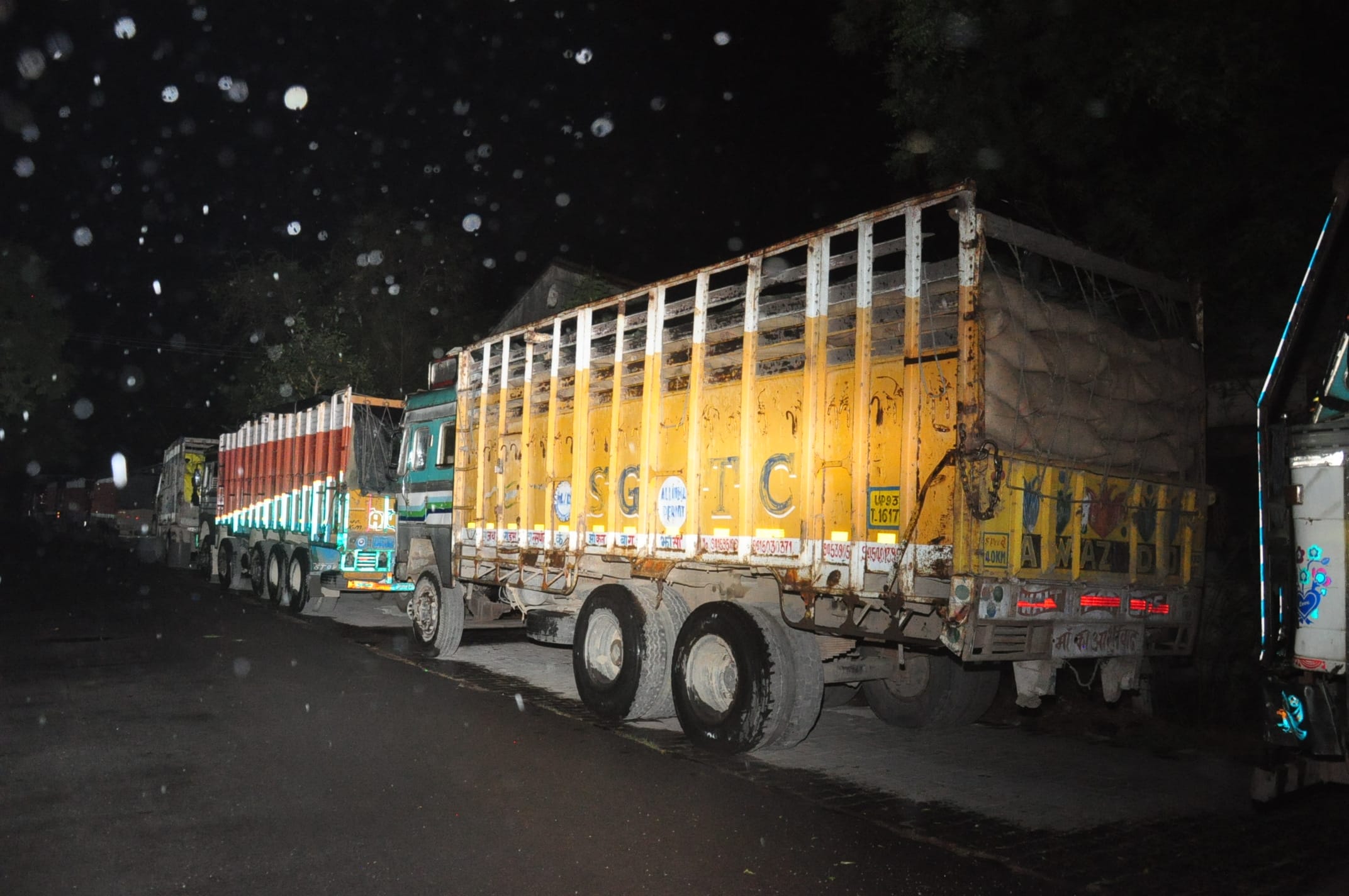 आरएफसी गोदाम के बाहर खड़े गेंहूँ से भरे कुछ ट्रकों को बरसाती से ठीक से ढका नहीं गया इससे बरसात में आरएफसी गोदाम के बाहर खड़े गेंहूँ से भरे कुछ ट्रकों को बरसाती से ठीक से ढका नहीं गया इससे बरसात में