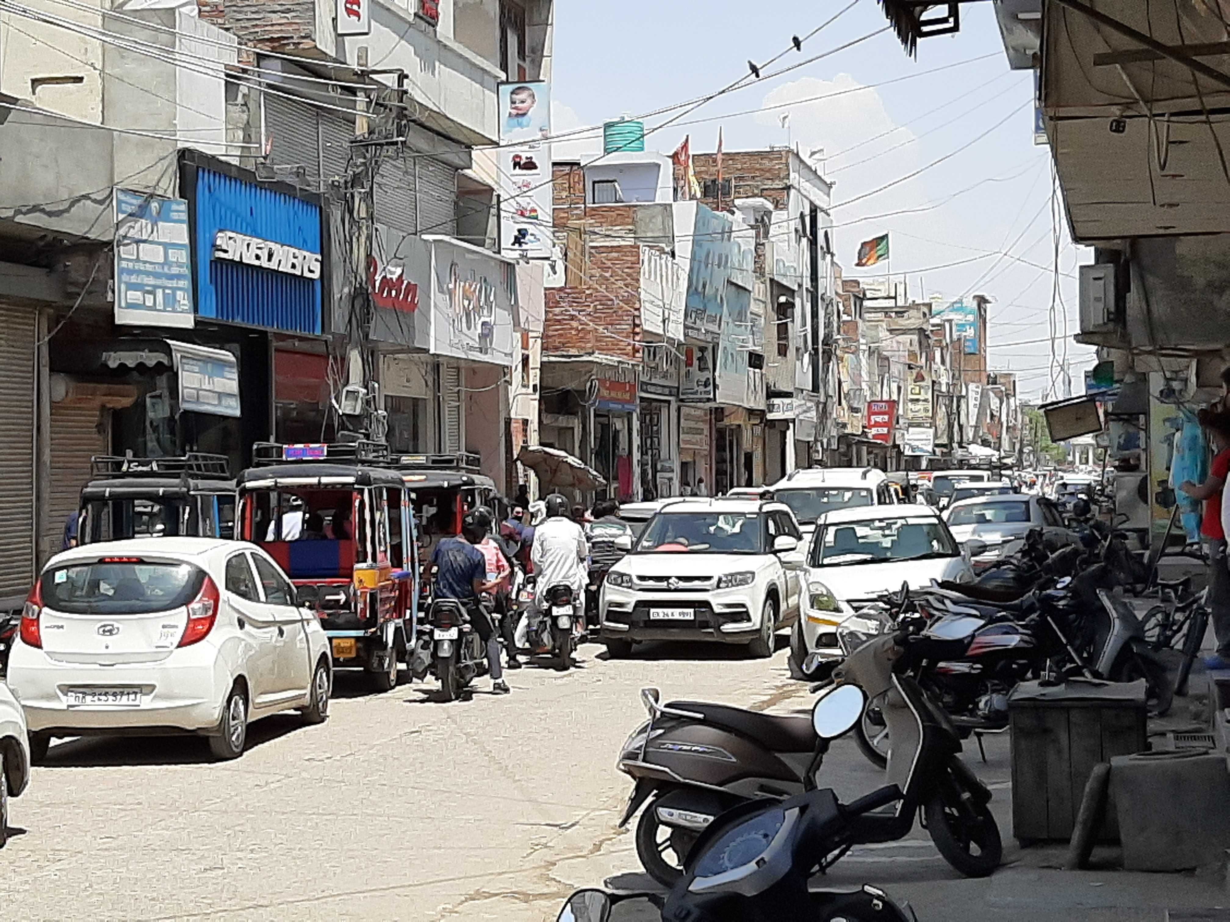 बाजार में जाम में फंसी गाड़ियां। बाजार में जाम में फंसी गाड़ियां।
