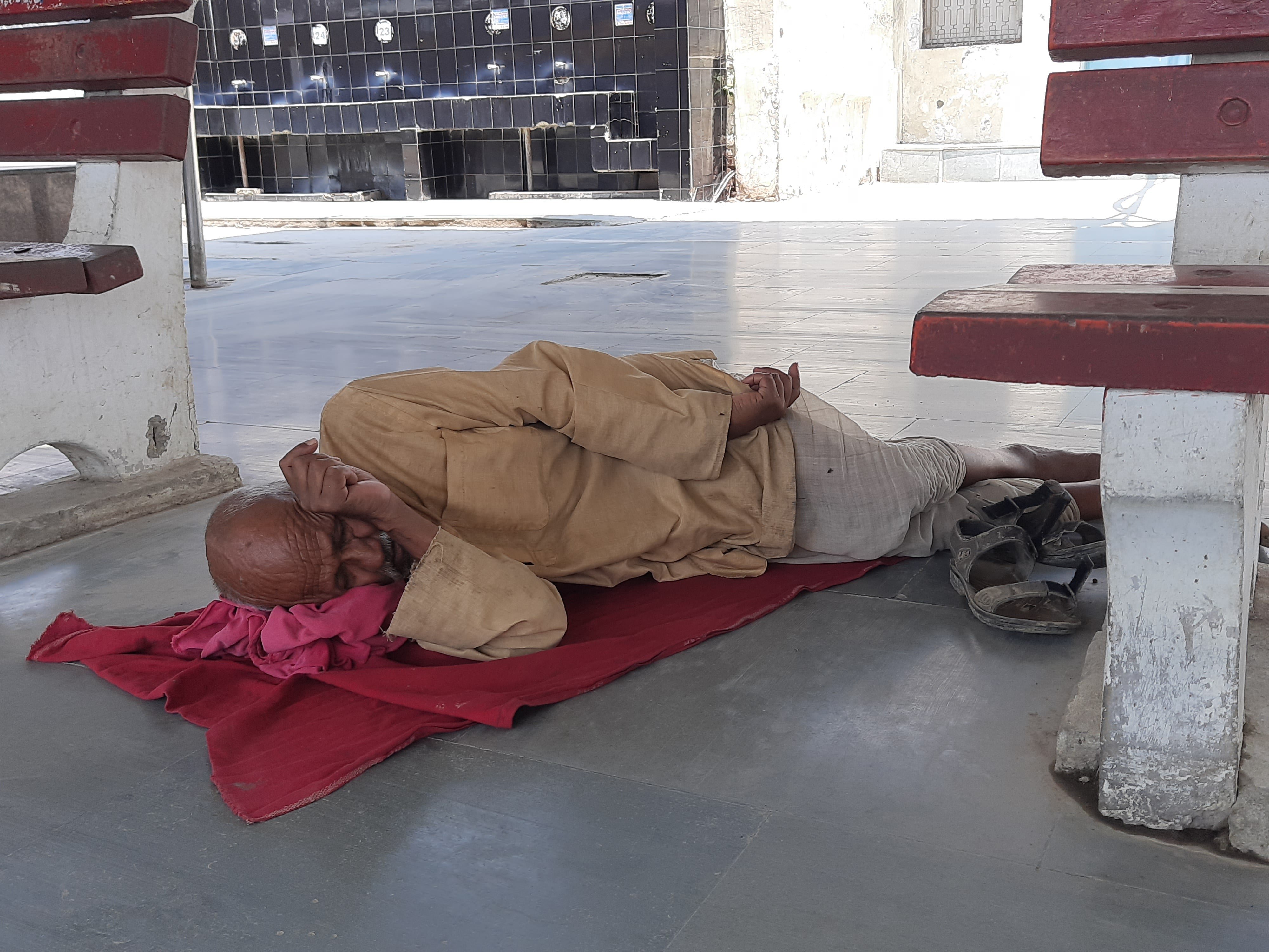 काम न होने से प्लेटाफार्म पर आराम करता एक कुली। काम न होने से प्लेटाफार्म पर आराम करता एक कुली।
