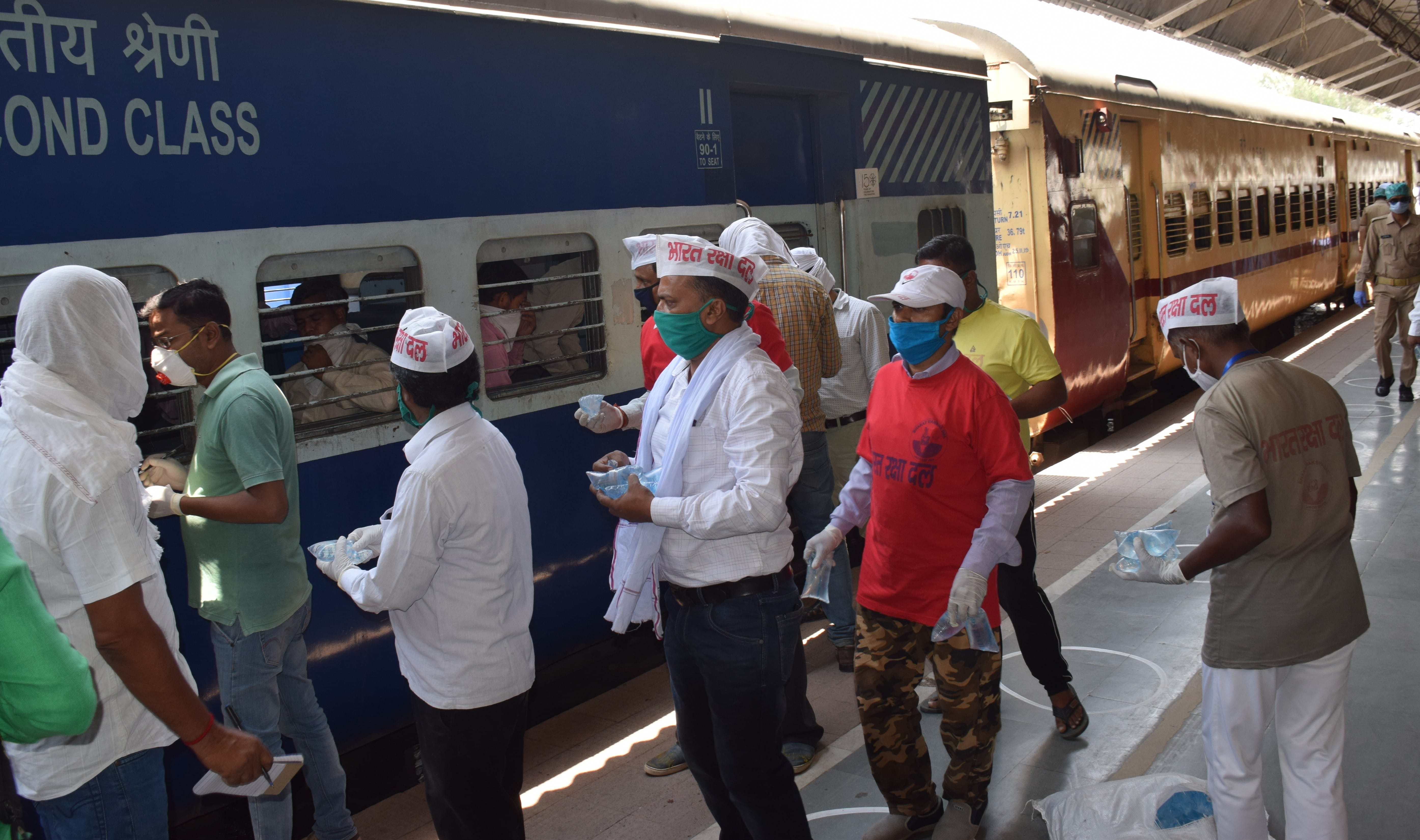 यात्रियों को पानी का पैकेट देता भारत रक्षा दल के कार्यकर्ता। यात्रियों को पानी का पैकेट देता भारत रक्षा दल के कार्यकर्ता।