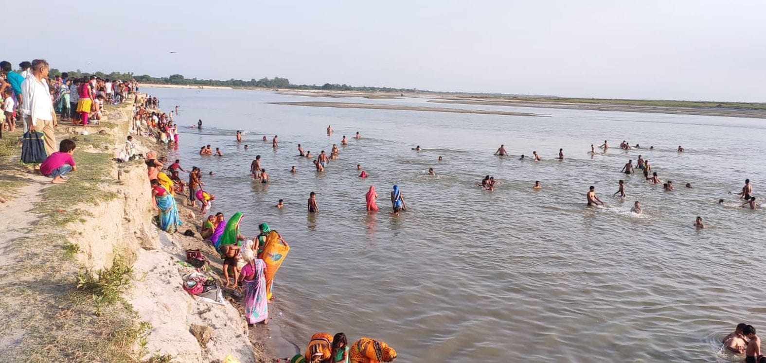 गंगा तट पर स्नान करते लोग। संवाद