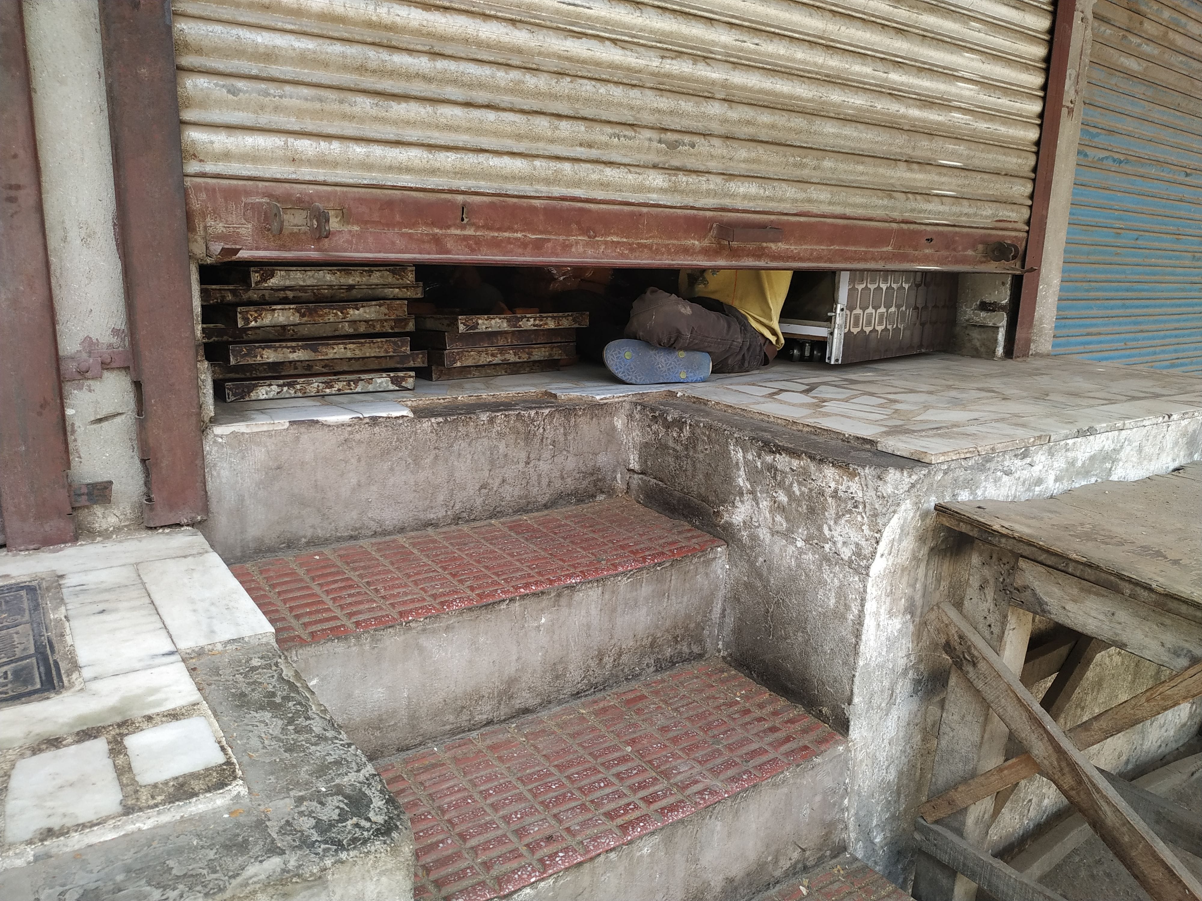 shopkeeper selling product by opening half shutter