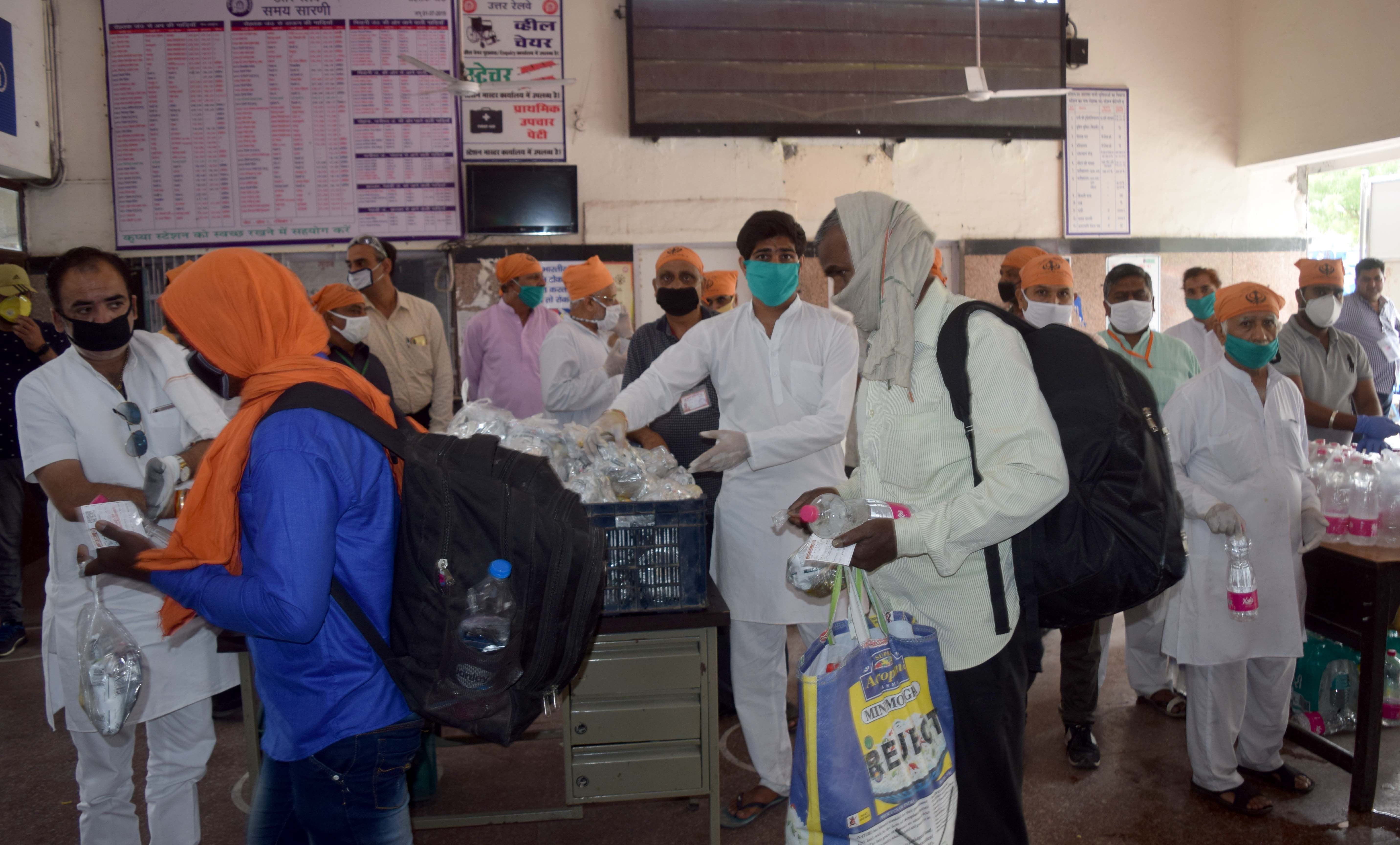 स्टेशन पर प्रवासी मजदूरों को खाना बांटते समाजसेवी। स्टेशन पर प्रवासी मजदूरों को खाना बांटते समाजसेवी।