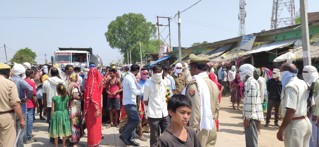 घटनास्थल पर खड़ा क्षतिग्रस्त ट्रक और मौके पर मौजूद भीड़। 