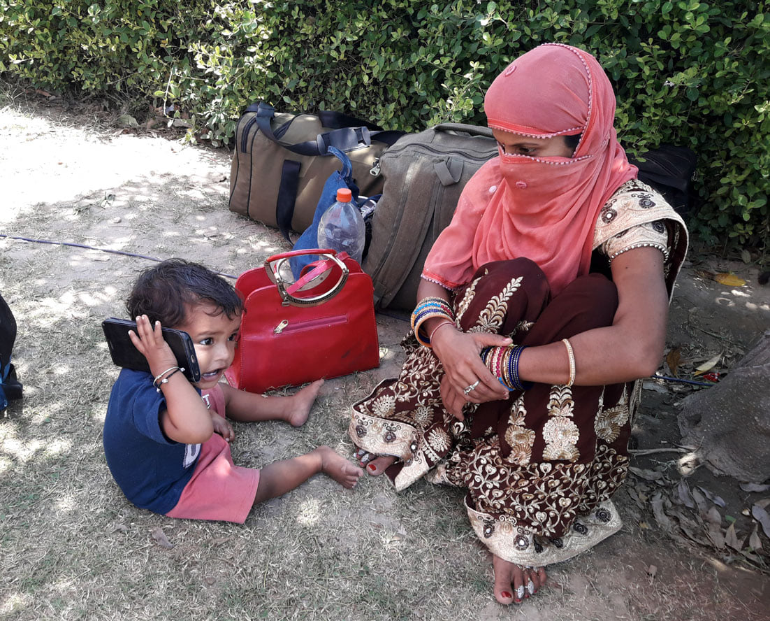 शहर स्थित अस्थाई आश्रय स्थल पर अपने ग्रह जनपद लौटने से पूर्व फोन पर अपने दादा से बात करता एक छोटा ब शहर स्थित अस्थाई आश्रय स्थल पर अपने ग्रह जनपद लौटने से पूर्व फोन पर अपने दादा से बात करता एक छोटा ब
