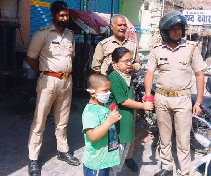 गंगोह में पुलिसकर्मी को गुलाब का पुष्प भेंट करते बच्चें