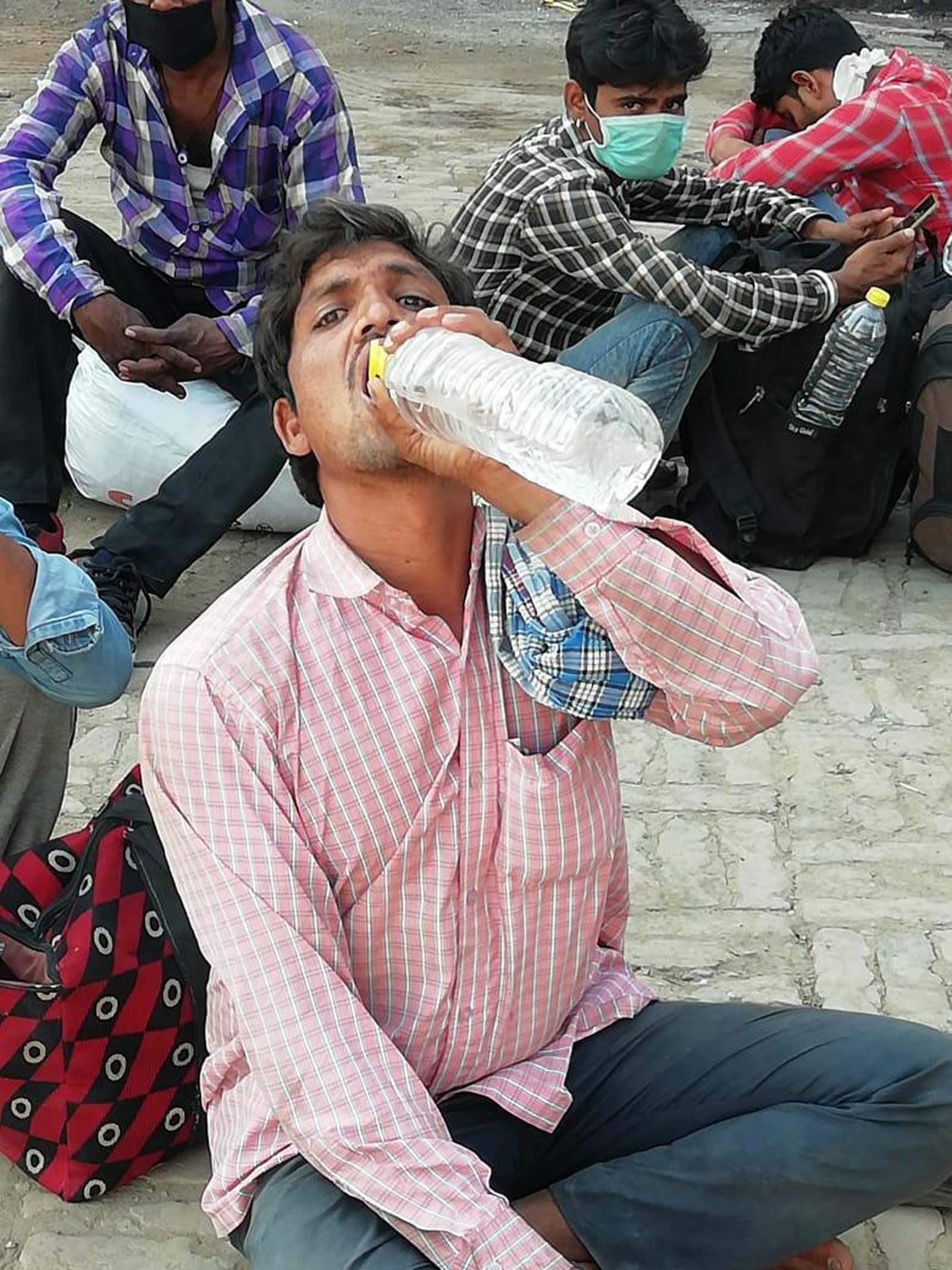 बहुत गर्मी है : शामली रोडवेज बस स्टैंड पर पानी पीकर प्यास बुझाता प्रवासी श्रमिक।