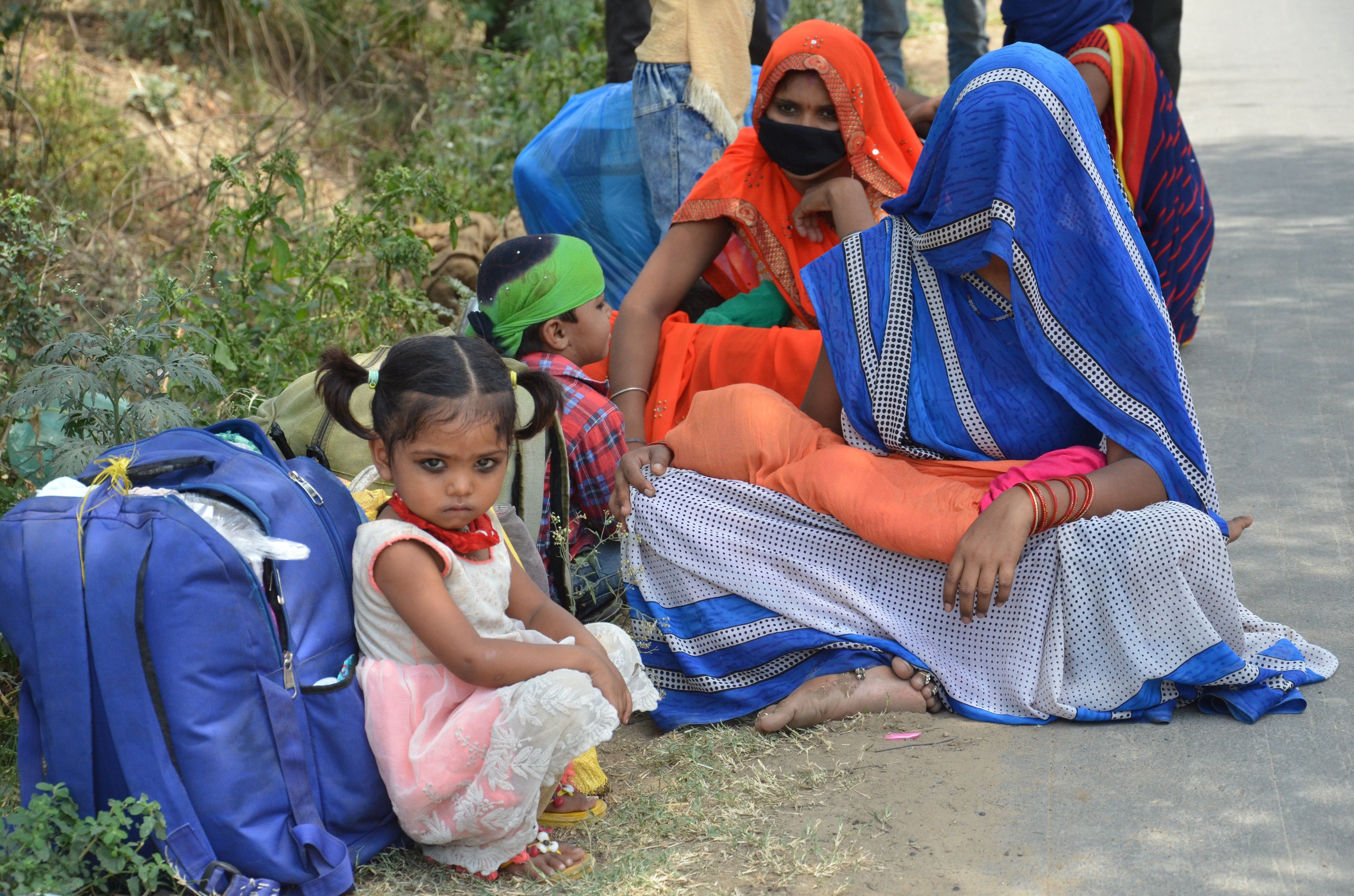 भिवानी-महम मार्ग पर पेड़ की छांव में बैठीं प्रवासी मजदूर महिलाएं। गर्मी अधिक होने के कारण कपड़े म