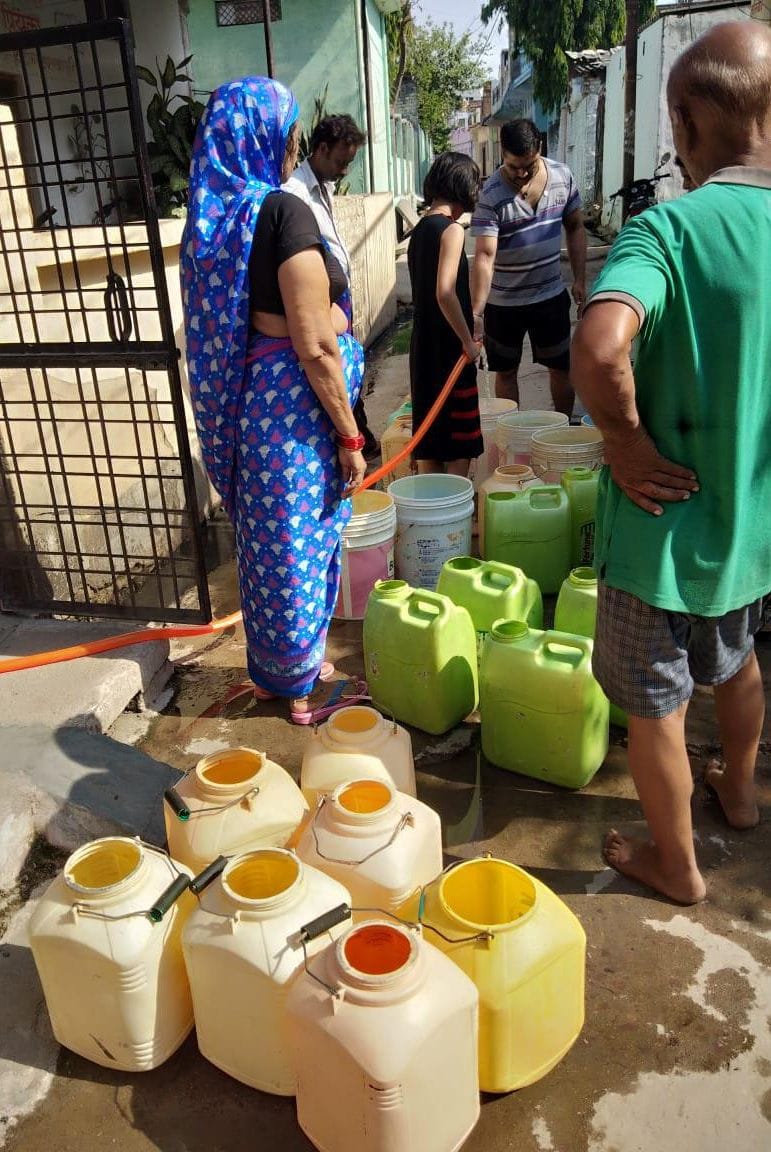 गांधी नगर में पारस मनया जैन अपने घर से मोहल्ला वासियों को दे रहे पानी