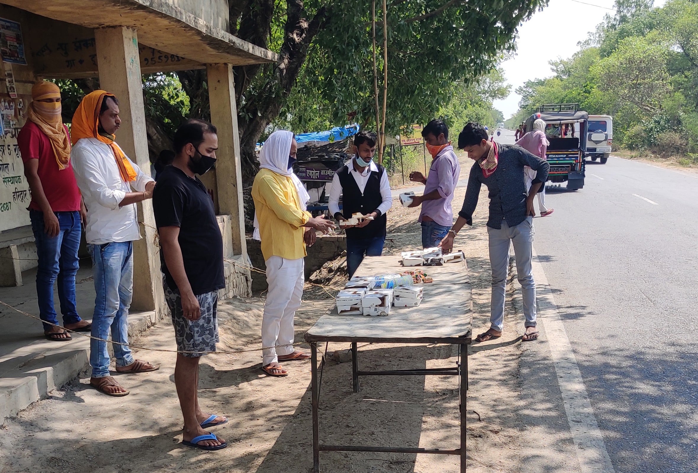 सैयदराजा-जमानियां मार्ग पर श्रमिकों को लंच पैकेट वितरित करते किसान युवा विकास मंच के पदाधिकारी।