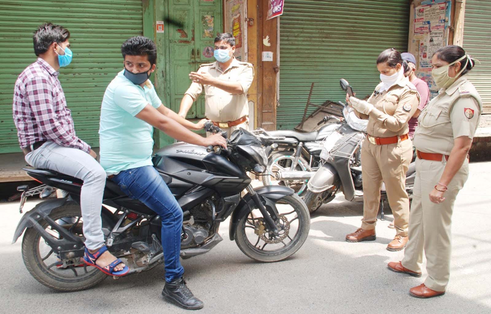 शामली के बाजार में अकारण घूमने वाले बाईक चालकों को चलान काटती महिला पुलिसकर्मी। शामली के बाजार में अकारण घूमने वाले बाईक चालकों को चलान काटती महिला पुलिसकर्मी।