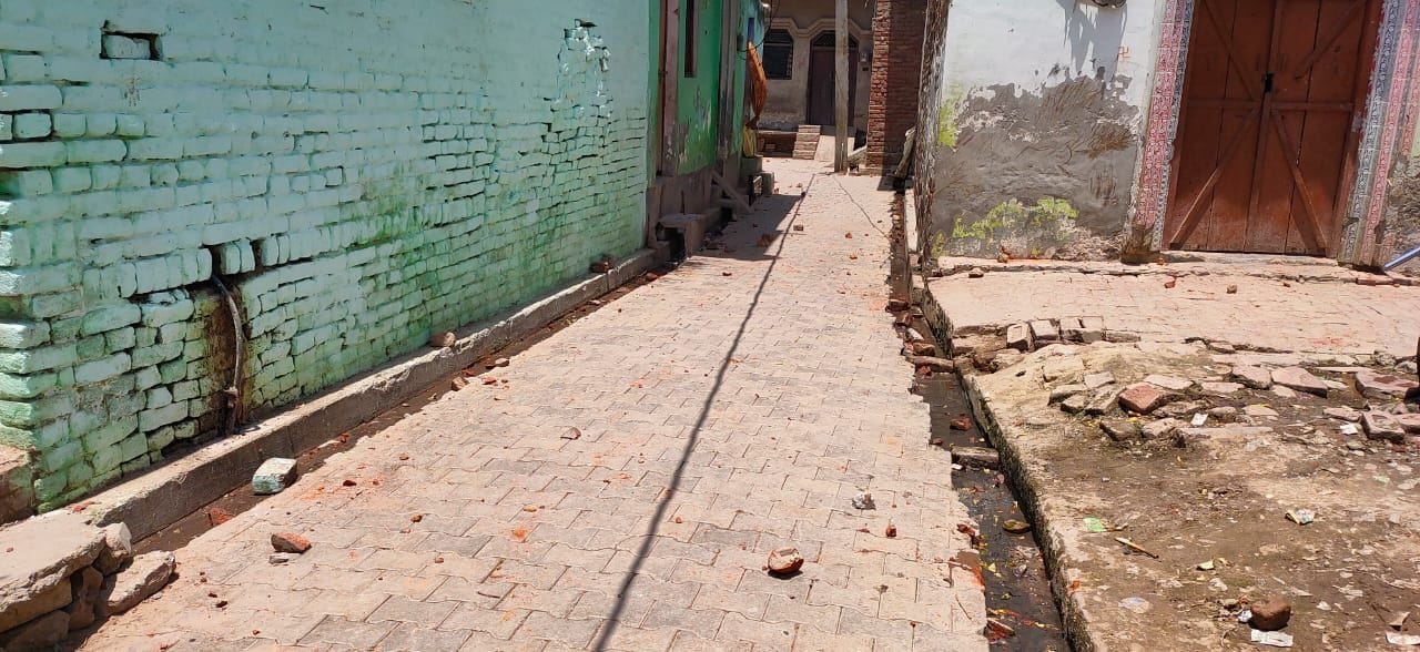 गली में बिखरे ईंट पत्थर। गली में बिखरे ईंट पत्थर।