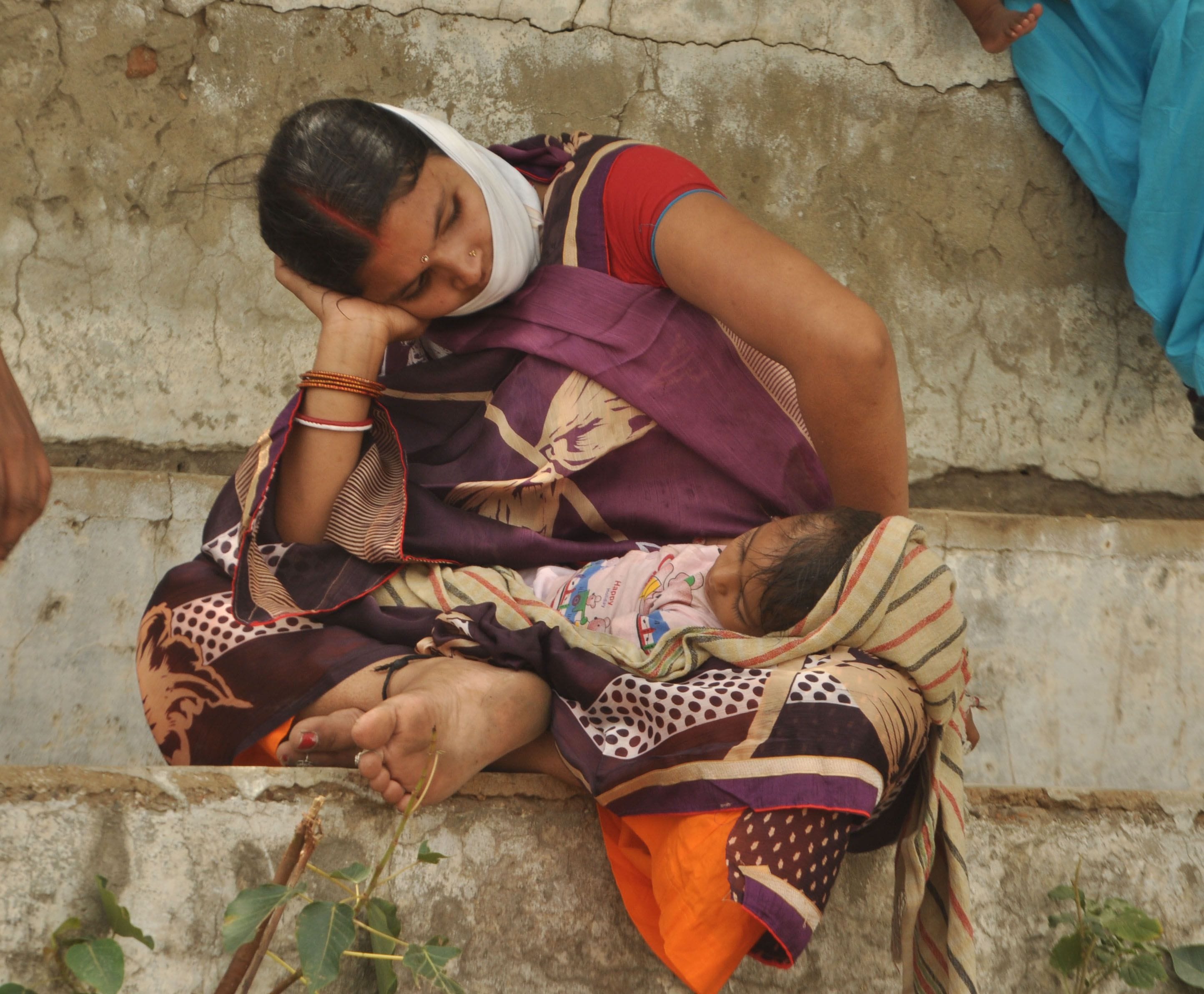 छोटूराम स्टेडियम में बस के इंतजार में बैठी महिला बच्चे को गोद में लिए हुए । संवाद छोटूराम स्टेडियम में बस के इंतजार में बैठी महिला बच्चे को गोद में लिए हुए । संवाद
