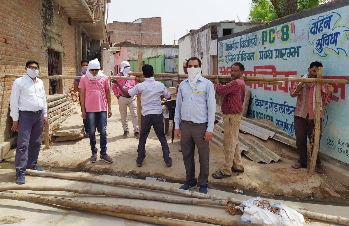 नेहरूनगर में बल्लियां लगाते कर्मचारी व मौजूद अधिकारी नेहरूनगर में बल्लियां लगाते कर्मचारी व मौजूद अधिकारी