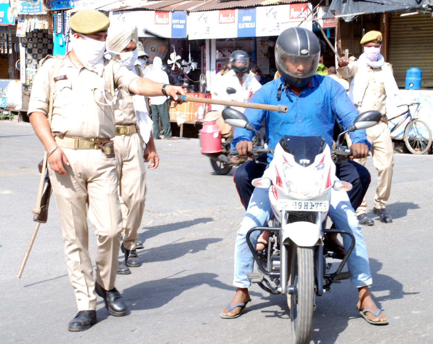 शामली में फव्वारा चौक पर बाइक सवार को रोकते पुलिसकर्मी। शामली में फव्वारा चौक पर बाइक सवार को रोकते पुलिसकर्मी।