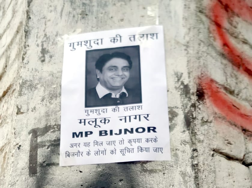 जिनौर के मोहल्ला चाहशीरी में दीवार पर लगे सांसद मलूक नागर के गुमशुदा के पोस्टर।