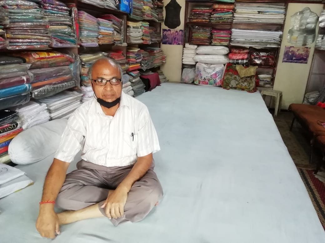 शामली में कपड़े की दुकान पर खाली बैठे व्यापारी