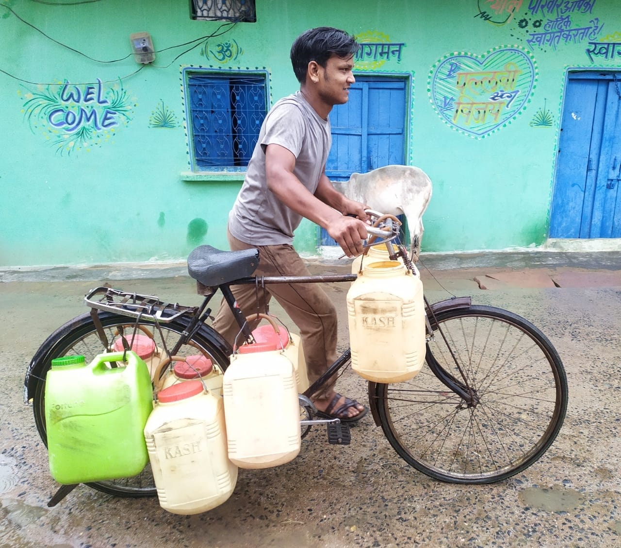 साइकिल पर कुप्पा बांधकर पानी ढोता युवक साइकिल पर कुप्पा बांधकर पानी ढोता युवक