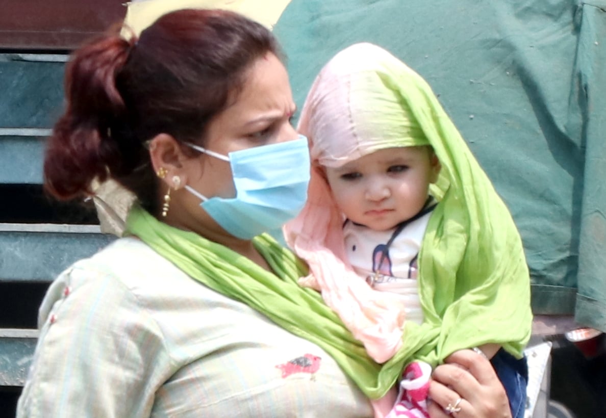 बिजनौर में गर्मी और तेज धूप से अपने बच्चे को बचाती एक मां। बिजनौर में गर्मी और तेज धूप से अपने बच्चे को बचाती एक मां।