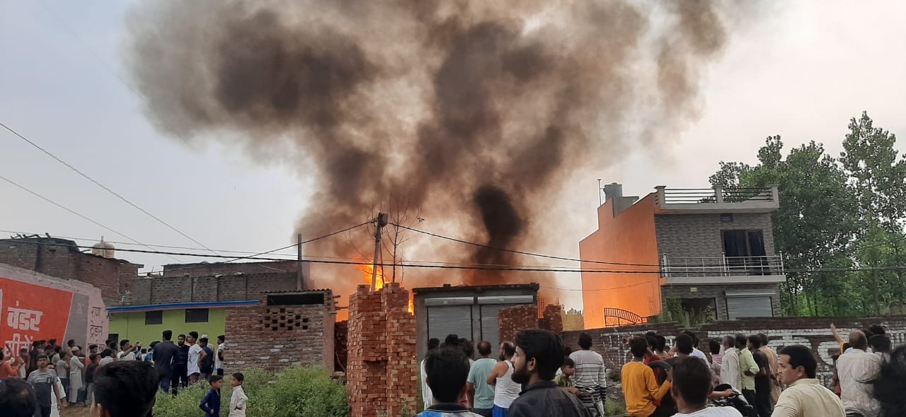 बेहट क्षेत्र में कबाड़ के ढेर से उठती आग की लपटें