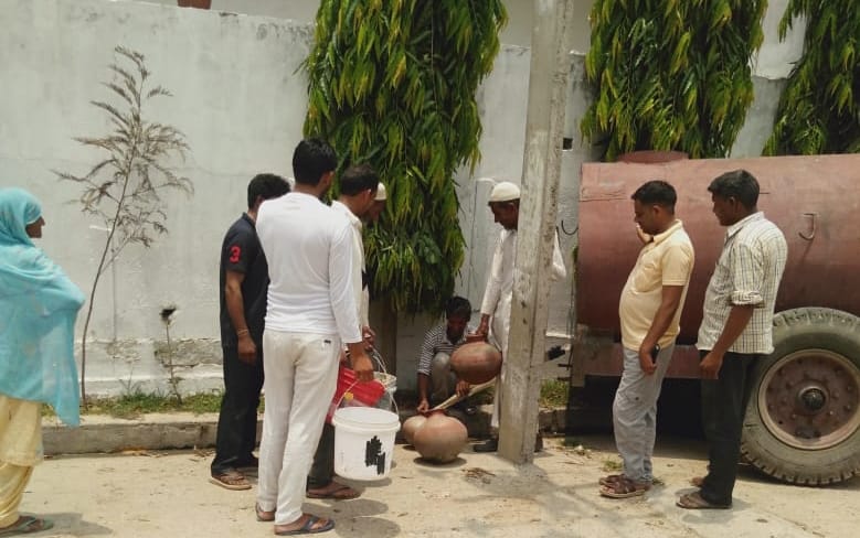 बेहट के कोठड़ी बहलोलपुर में टैंकर से पानी भरते ग्रामीण।