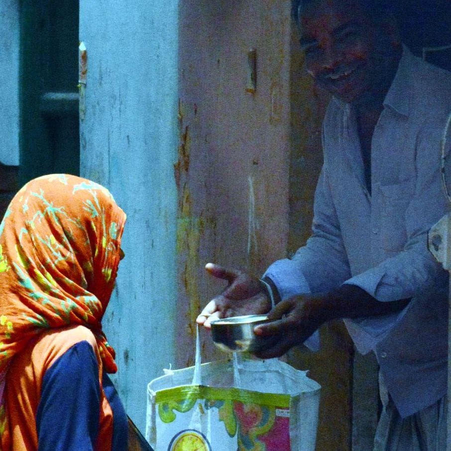 सूर्य ग्रहण के दौरान दान करते श्रद्धालु।