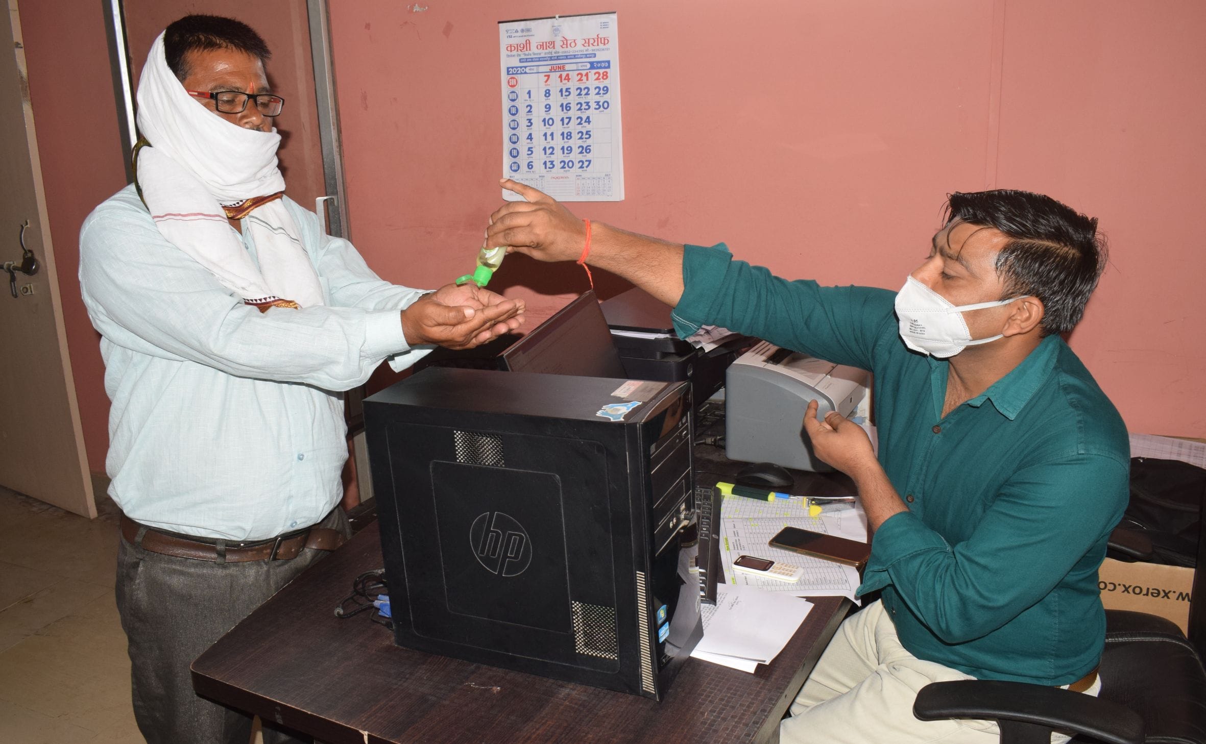 फोटो-9-बीएसए आफिस स्थित अपने कार्यालय में आने वाले लोगों के हाथ सैनिटाइज कराते एमआईएस इंचार्ज शैल