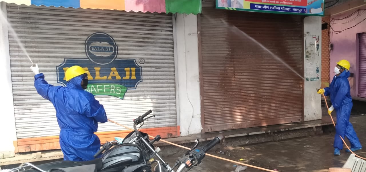 धामपुर में थाने के बाहर के क्षेत्र को सैनिटाइज करती पालिका टीम ।