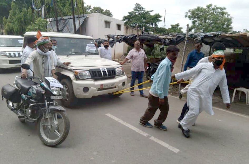 चार पहिया गाड़ी खींचते कांग्रेस कार्यकर्ता। संवाद चार पहिया गाड़ी खींचते कांग्रेस कार्यकर्ता। संवाद