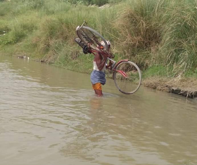 सैदनगर क्षेत्र के लालपुर में साइकिल कंधे पर रखकर कोसी नदी पार करता राहगीर। फोटो-संवाद न्यूज एजें? सैदनगर क्षेत्र के लालपुर में साइकिल कंधे पर रखकर कोसी नदी पार करता राहगीर। फोटो-संवाद न्यूज एजें?