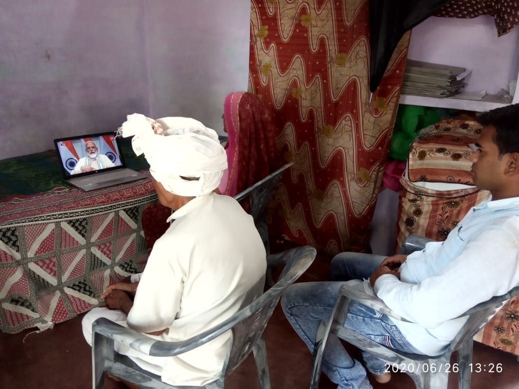 गांव में लैपटॉप पर प्रधानमंत्री नरेंद्र मोदी को लाइव सुनते किसान गांव में लैपटॉप पर प्रधानमंत्री नरेंद्र मोदी को लाइव सुनते किसान