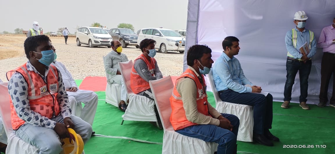 जालौन के बरहा गांव में पीएम नरेंद्र मोदी की बात सुनते डीएम के साथ बैठे प्रवासी मजदूर।