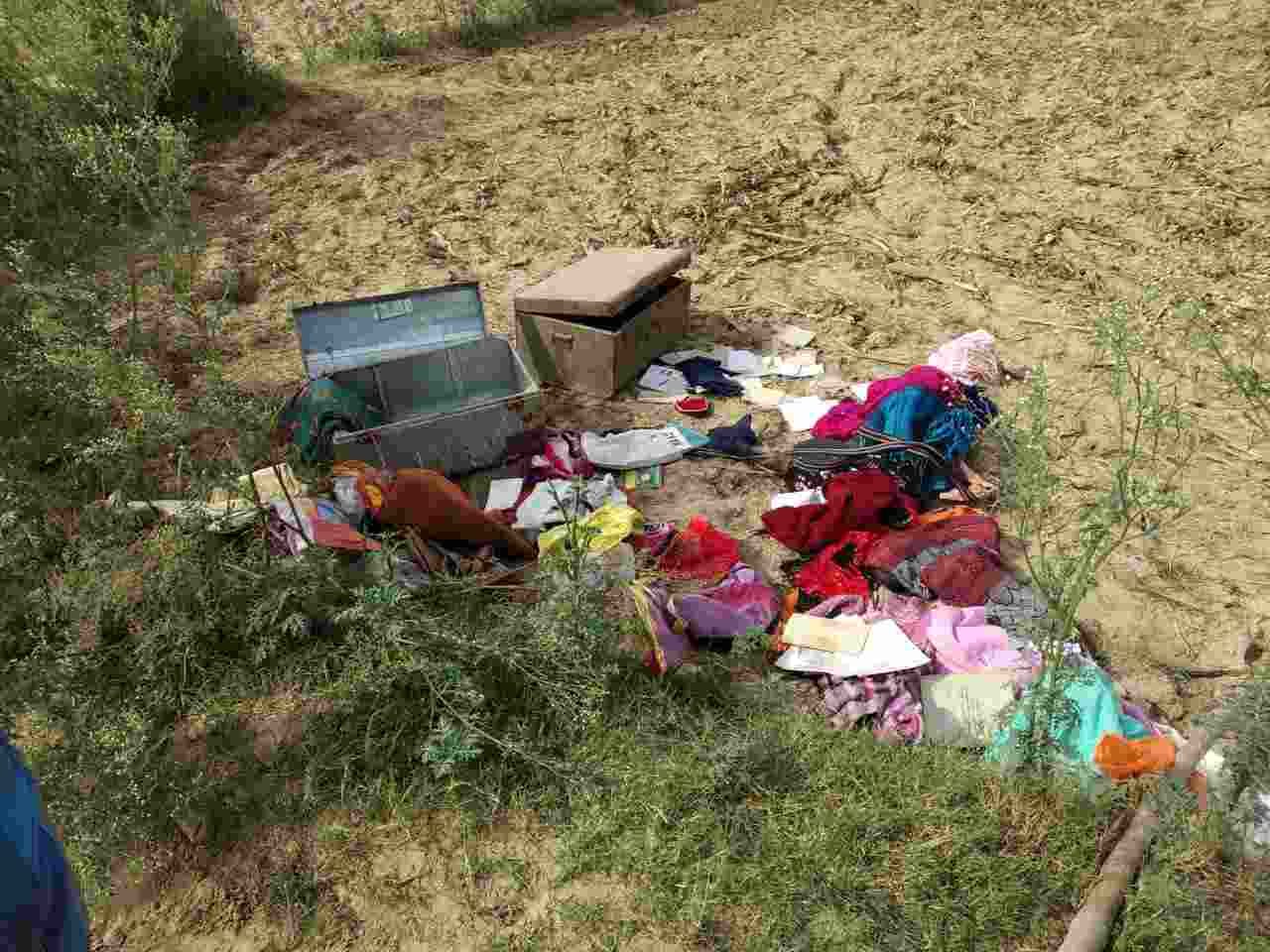 फोटो 28एयूआरपी10- गांव के बाहर खेत में पड़ा बक्सा व कपड़े