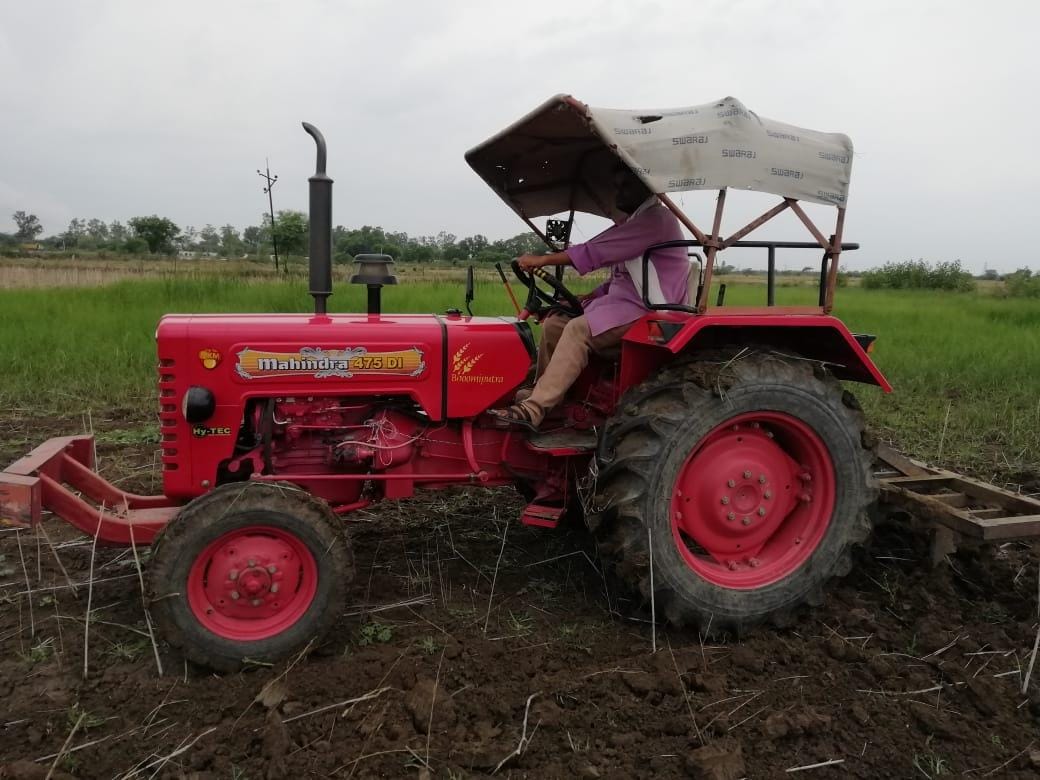 खेत में ट्रैक्टर जुताई करता खेत में ट्रैक्टर जुताई करता