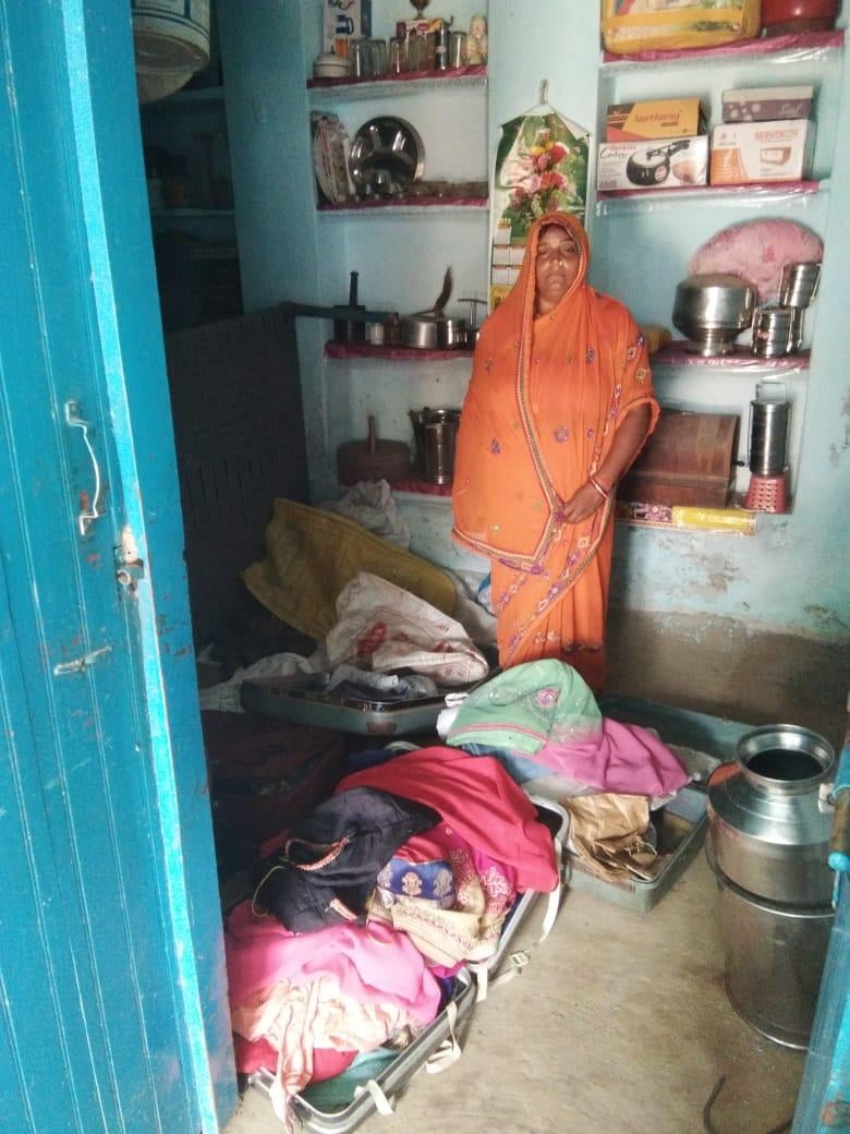 माधौगढ़ में चोरों द्वारा फैलाया गया सामान दिखाती गृहिणी
