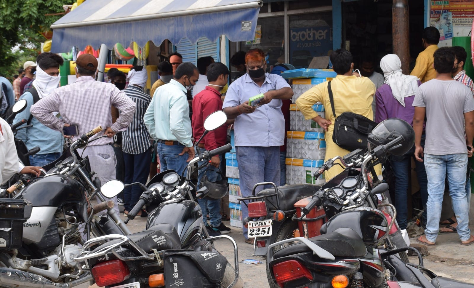 नगर पालिका तिराहे के एक दुकान पर बिना सामाजिक दूरी के खरिदारी करते लोग।