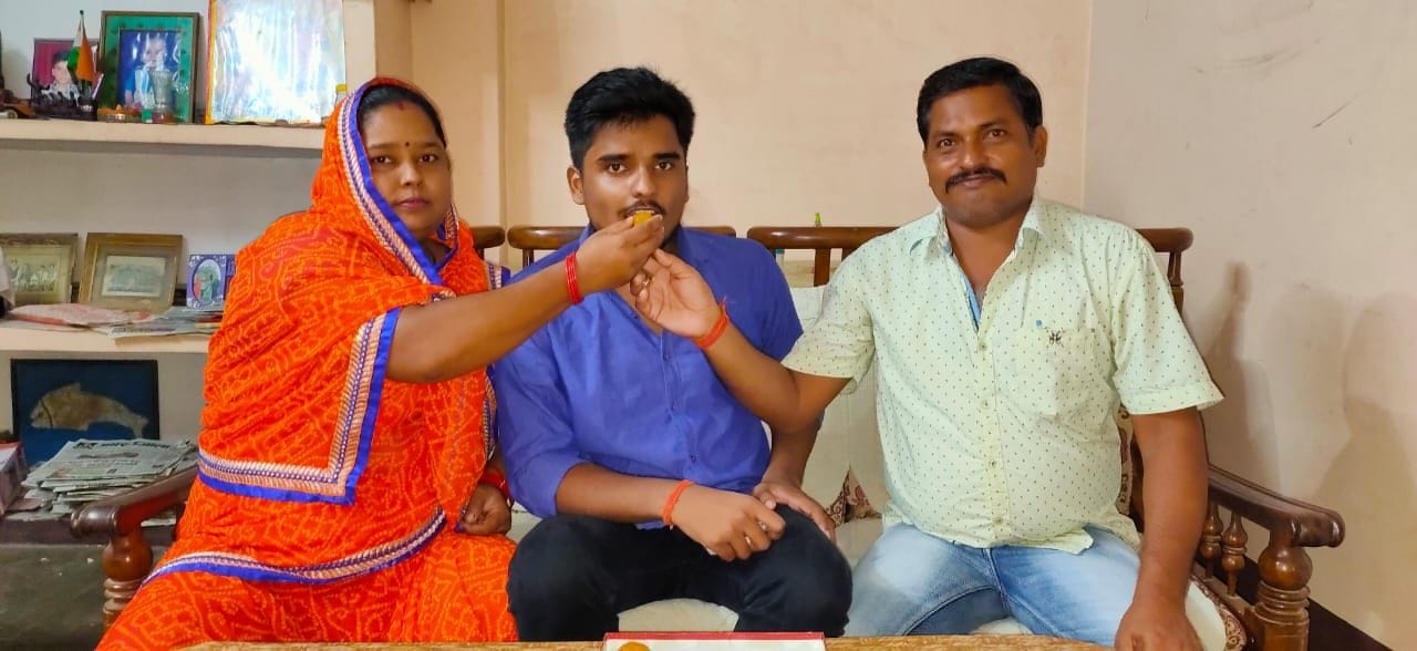 आईसीएसई बोर्ड इंटर में जिले में प्रथम आये अमन सोमवंशी को मिठाई खिलाते माता पिता।