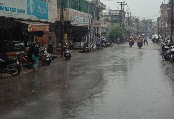 शहर में सुबह हुई बरसात के दौरान जाते राहगीर। शहर में सुबह हुई बरसात के दौरान जाते राहगीर।
