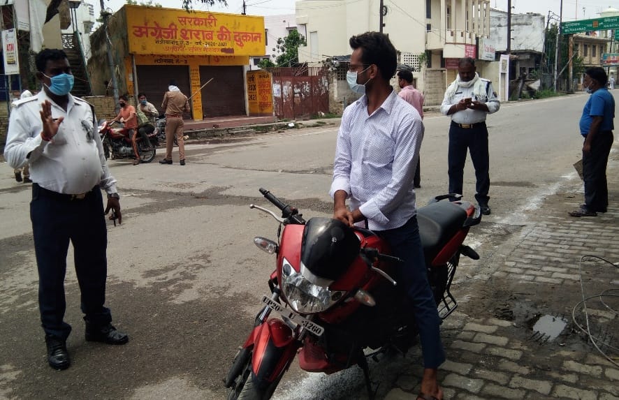 नजीबाबाद के मालगोदाम तिराहे पर लॉकडाउन के दौरान हेलमेट न लगाने पर चालान करती यातायात पुलिस। नजीबाबाद के मालगोदाम तिराहे पर लॉकडाउन के दौरान हेलमेट न लगाने पर चालान करती यातायात पुलिस।
