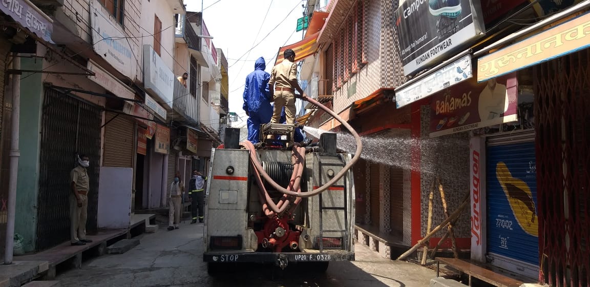 धामपुर में मेन बाजार में हॉट स्पॉट बने क्षेत्र को सैनिटाइज करते दमकल कर्मी।