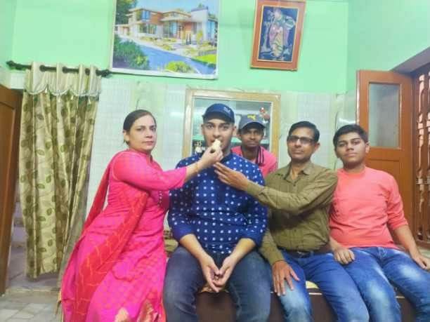 हर्षित मेहरे को मिठाई खिलाते उनके माता-पिता। हर्षित मेहरे को मिठाई खिलाते उनके माता-पिता।