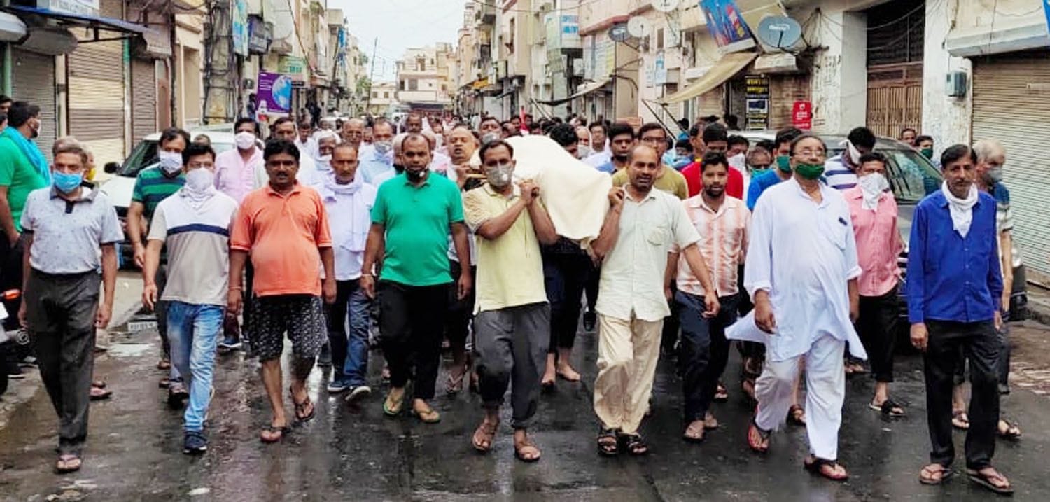 दुकानदार का अंतिम संस्कार करने जाते व्यापारी और परिजन।