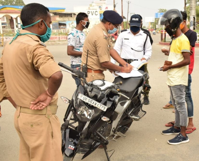 रुद्रपुर के डीडी चौक में बाइक सवार का चालान करते ट्रैफिक इंस्पेक्टर। रुद्रपुर के डीडी चौक में बाइक सवार का चालान करते ट्रैफिक इंस्पेक्टर।